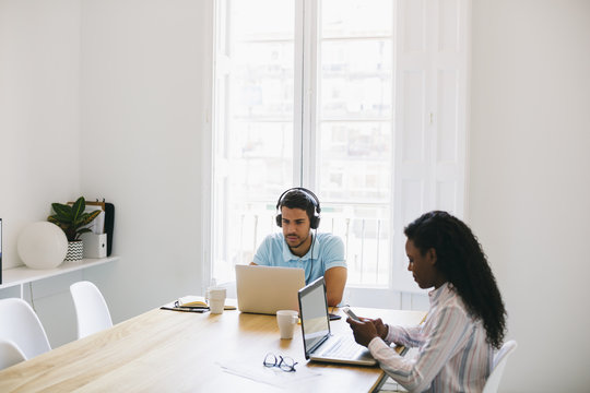 Young businessman and woman working together in office, using laptop
