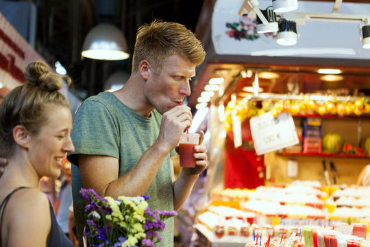 Man drinking smoothie on a street market