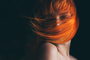 Red hair girl portrait in black background