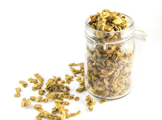 Healthy breakfast. Fresh granola, muesli in a glass jar. Organic oat,almond and sunflower seeds isolated (focus on granola in glass jar)