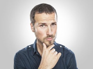 Portrait of handsome young thoughtful man isolated over white ba