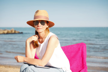 Fototapeta na wymiar Ejoying summer on seaside. Beautiful woman relaxing on the beach.