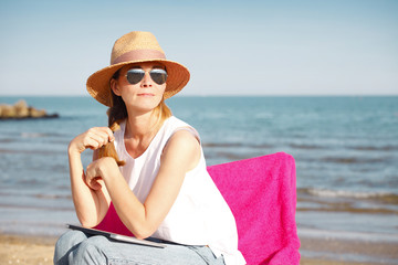 Fototapeta na wymiar Ejoying summer on seaside. Beautiful woman relaxing on the beach.