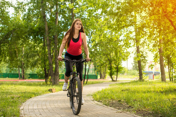 Naklejka premium Happy girl cyclist riding on a mountain bike outside