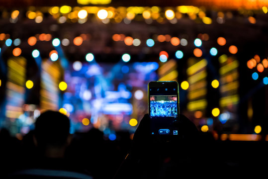 People holding their smart phones shooting video or photo.