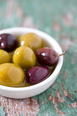 olives in a bowl on wooden surface