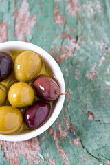 olives in a bowl on wooden surface