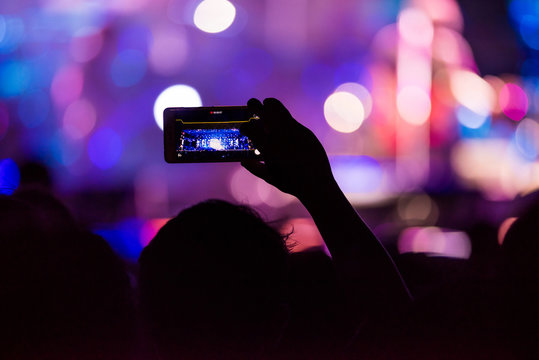 People holding their smart phones shooting video or photo.