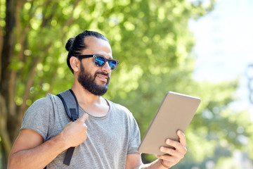 Fototapeta premium man traveling with backpack and tablet pc in city