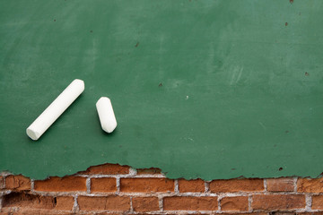 board on cracked concrete vintage wall background with Chalks.