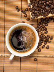 Coffee cup and beans on wooden,top view