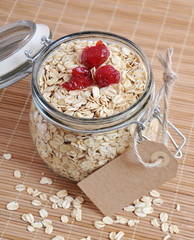 Rolled oats or oat flakes in jar with manila price tag. Healthy lifestyle concept.