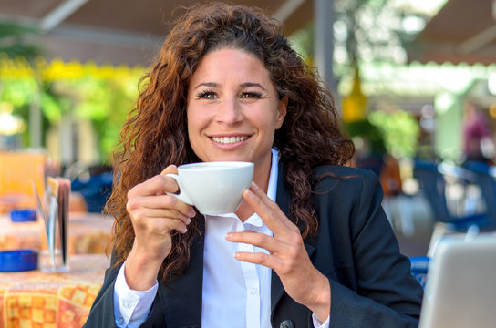 Exultant young woman enjoying a cup of coffee