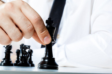 Hand of businessman playing chess