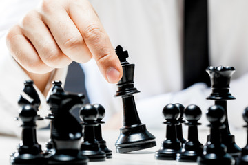 Hand of businessman playing chess