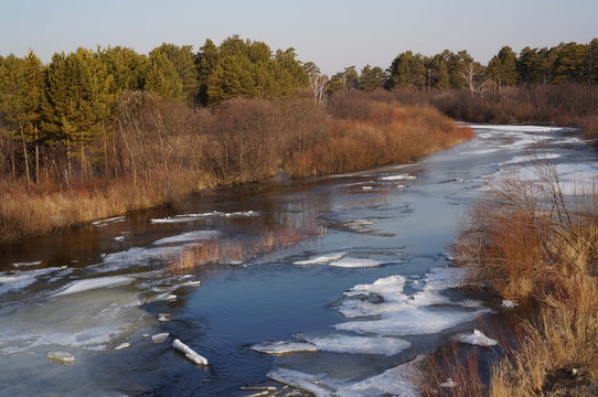 Ice drift on the forest river 