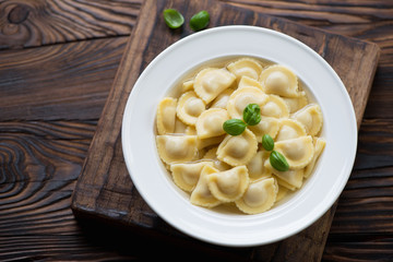 Glass plate with ravioli in bouillon, close-up