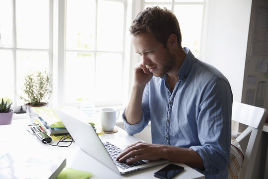 Young Man Working On Laptop Computer