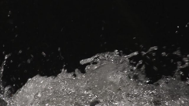 Splashing, bubbling clear water on a black frame