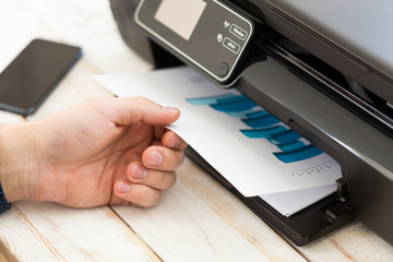 Man's hand making copies. Working with printer