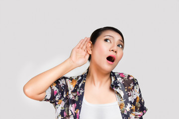 Woman holds her hand near ear and listens