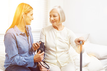 Blutdruckmessung bei Seniorin im Pflegeheim