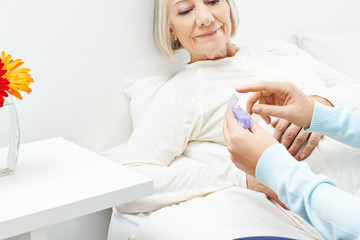 Seniorin im Pflegeheim bekommt Medizin