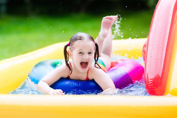 Fototapeta na wymiar Little girl in garden swimming pool