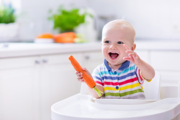 Little baby eating carrot