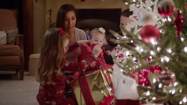 Medium shot of family opening Christmas presents / Cedar Hills, Utah, United States