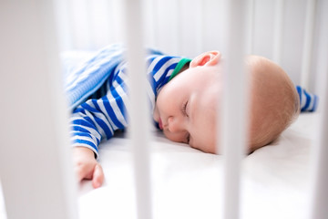 Sleeping baby boy in white crib