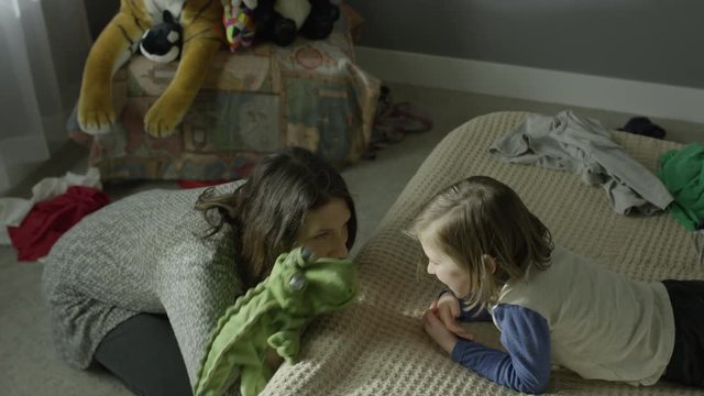 Medium high angle panning shot of mother playing with son with sock puppet / Cedar Hills, Utah, United States