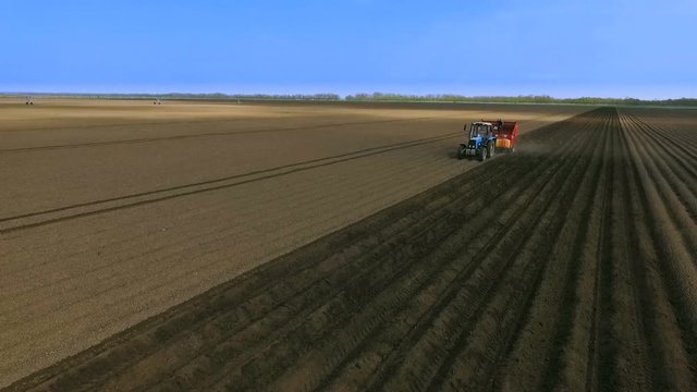 An Aerial View of a Tractor Planting Potatoes in the Fertile Fields of the Farm in the Spring.The Introduction of Fungicides