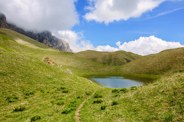 Fototapeta na wymiar Mountainous landscape, mountain lake, the path leading far calling in search of adventure