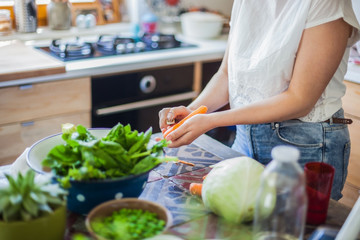Woman cooking in kitchen with ingredients around her