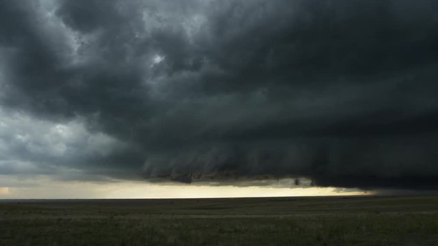 Darkening shelf cloud over prairie landscape, time lapse