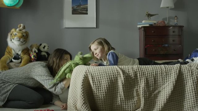 Medium panning shot of mother playing with son with sock puppet / Cedar Hills, Utah, United States