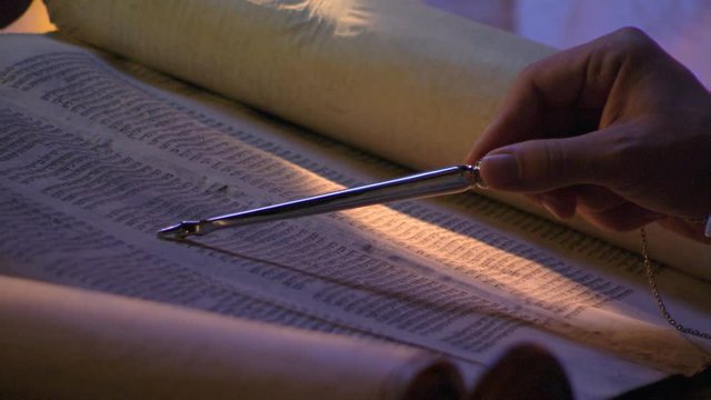 Close-up of opened Torah, stylus following lines from right to left
