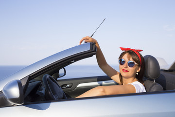 Young woman drive a car on the beach.