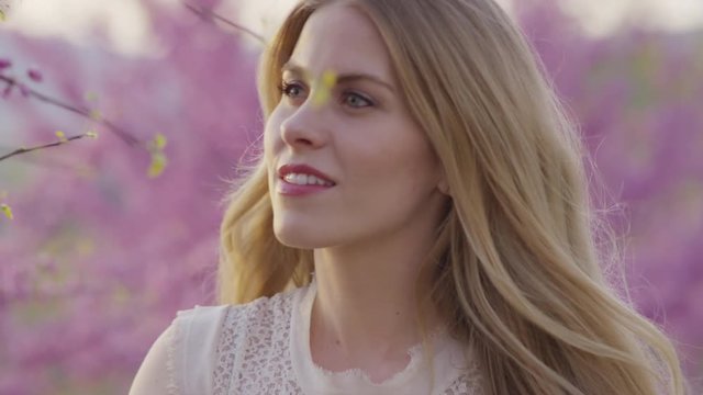 Close up slow motion panning shot of woman smelling flowers in park / Cedar Hills, Utah, United States