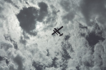 A plane flying in the sky on a cloudy day