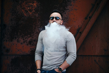 Vaper with beard in sunglasses vaping outdoor