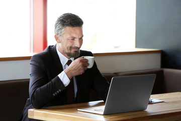 Businessman with laptop in cafe