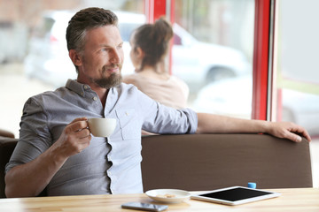 Businessman resting with cup of coffee in cafe