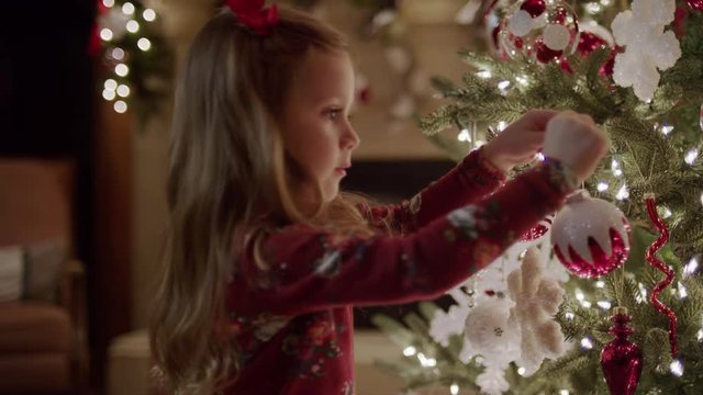 Medium panning shot of family decorating Christmas tree / Cedar Hills, Utah, United States