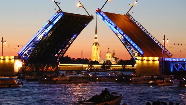 Tourists on the boat watching the divorce of the Palace bridge in St. Petersburg during the white night