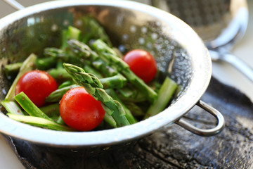 Asparagus with tomatoes in colander