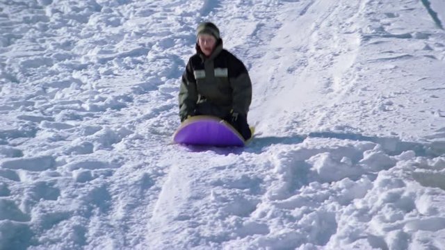 Children sledding on a snowy slope