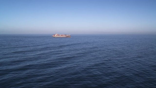 A container ship on the horizon in open ocean