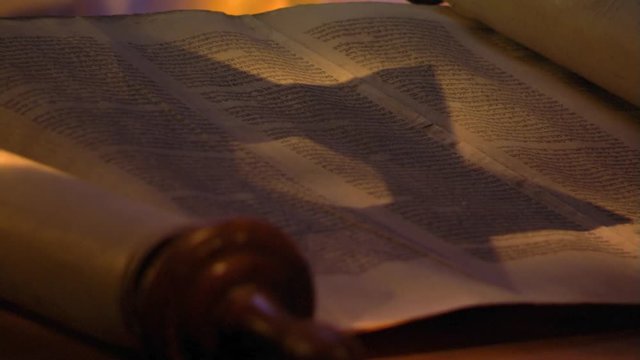 Close-up of opened Torah, shadow of Star of David falling on page